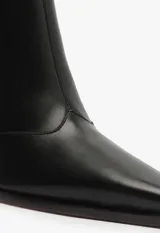 Bota de media caña en cuero negro, con diseño de punta fina y taco cuadrado alto. Presenta cierre lateral interno y una silueta estructurada.