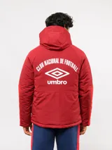 Campera de abrigo Umbro del Club Nacional de Football, con diseño de bloques de color en azul, blanco y rojo. Cuenta con capucha ajustable, cierre frontal y logo de la marca junto al escudo del club en el pecho.
