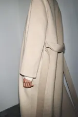 Abrigo largo de corte minimalista confeccionado en mezcla de lana, con diseño de solapas integradas, manga larga y cinturón ajustable del mismo tejido.