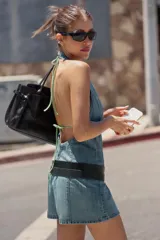 Mono corto de denim con cuello halter, espalda descubierta y costuras marcadas.