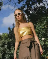 Top corto estilo corset o bandeau, color dorado metálico, con tirantes anchos ajustables.