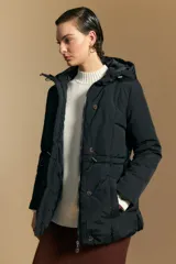 Campera acolchada de nylon en color crema, con capucha ajustable, cierre frontal con botones y cordón de ajuste en la cintura.