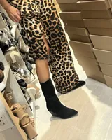 Botas de caña media color negro, confeccionadas en gamuza, con punta fina y taco geométrico.