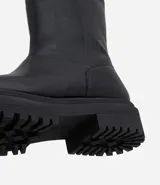Bota de caña alta confeccionada en PU, con suela tractorada robusta y puntera redondeada. Diseño moderno y versátil con taco de 5,3 cm.