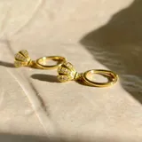 Par de aros dorados con forma de moño con incrustaciones de circonitas.