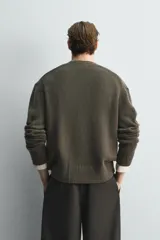 Cárdigan de punto con mezcla de lana y cashmere, de corte relajado, cuello en pico y cierre frontal con botones. Presenta mangas largas con puños acanalados y dos bolsillos de plastrón en la parte frontal.