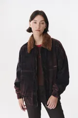 Campera de jean con efecto desgastado en tonos oscuros, corte oversized y diseño con volados frontales. Cuenta con cuello de piel sintética desmontable, cierre frontal, puños y ruedo elásticos, y logo bordado en el pecho.
