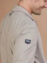 Campera bomber gris claro con cierre frontal y bolsillos laterales.