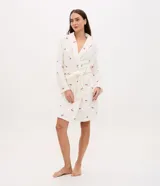 Bata de baño de corte regular confeccionada en tejido fleece de tacto suave y aspecto peludo. Presenta diseño de manga larga, abertura frontal con lazo ajustable en la cintura y bolsillos laterales. Cuenta con un estampado integral de cerezas sobre fondo blanco.
