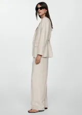 Pantalon de vestir de corte wideleg en color beige con estampado de raya diplomática. Cuenta con cintura alta, trabillas, cinturón desmontable, bolsillos laterales y bolsillos de ribete en la parte posterior.