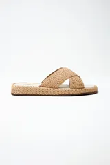 Sandalias bajas color beige con tiras cruzadas de yute y suela plana.