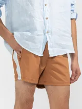 Short de baño para hombre color azul marino, con calce relajado y una tira lateral blanca estilo tuxedo. Presenta cintura elástica con cordón regulable, bolsillos laterales y trasero con cierre.