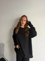 Buzo de punto color marrón chocolate, con cuello redondo y diseño holgado de manga larga con textura de trenzas verticales.