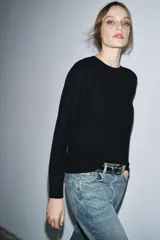 Jersey de punto liso color verde, con cuello redondo y manga larga. Confeccionado en lana suave.