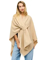 Ruana de tejido soft color negro, con cuello en V y un nudo o pasador frontal que ajusta la prenda. Los bordes tienen terminación desflecada.