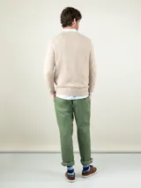 Sweater de lana merino color camel, de cuello redondo, mangas largas y diseño clásico, con pequeño logo bordado en el pecho.