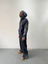 Campera reversible con cierre frontal. Un lado confeccionado en algodón azul marino con estampa plastisol, bordados con apliques y capucha. El otro lado presenta un diseño de polar de pelo largo en color gris. Posee corte oversize, puños y ruedo acanalados.