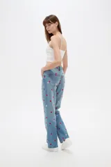 Pantalón jean de tiro alto y corte recto, color azul claro, con bordados de pequeños corazones rojos y rosados en toda la prenda.
