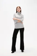 Polera de tejido de punto color gris, con cuello alto, mangas 3/4 y diseño holgado.