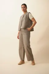 Chaleco color beige con textura tipo espiga, corte holgado y solapa cruzada.