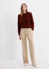 Sweater marrón de punto con volantes en los hombros, cuello redondo y mangas largas.
