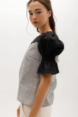 Blusa de corte relajado con cuerpo a rayas horizontales y mangas cortas abullonadas de color sólido. Presenta escote redondeado y puños con elástico.