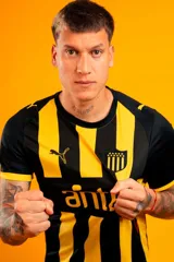 Camiseta de fútbol Puma del Club Atlético Peñarol, modelo Away Jersey Dandelion. Diseño a rayas verticales negras y amarillas con cuello redondo y detalles en negro en las mangas. Incluye el logo de Puma, el escudo del club y sponsor en el frente.