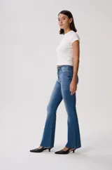 Pantalón jean de corte oxford, color blanco, con silueta ajustada en caderas y muslos y botamanga acampanada. Cuenta con bolsillos clásicos y costuras pespunteadas en contraste.