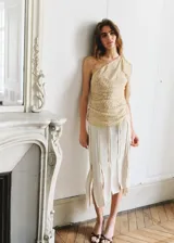 Top asimétrico de un solo hombro en color beige con textura sutil y drapeado lateral.