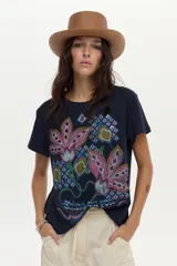 Remera de algodón azul marino de manga corta, con estampa frontal de flores grandes en tonos rosados y motivos geométricos, y detalle de bordado.