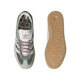 Championes Adidas Handball Spezial con diseño retro, confeccionados en una combinación de gamuza y tejido acanalado. Presentan una paleta de colores en tonos oliva, gris y crema, con las icónicas tres bandas laterales en blanco y suela de goma color caramelo.