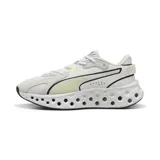 Championes Puma modelo Softride Frequence, color gris claro con detalles en amarillo flúor. Presentan una suela con diseño perforado distintivo y el logo de la marca en el lateral.