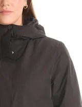 Campera 3 en 1 de color beige, con sistema de capas desmontables. La capa exterior es de tejido técnico resistente al viento y lluvia ligera, con capucha fija, cierre frontal con solapa, bolsillos de parche y ajuste elástico interno en la cintura. Incluye una campera interior capitoneada ultraliviana que puede usarse de forma independiente.