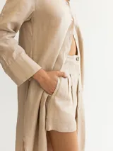 Short color beige de lino con pinzas y bolsillos laterales.