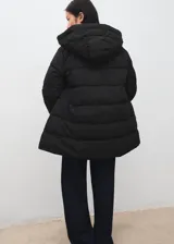 Campera puffer negra con capucha, diseño acolchado, cuello alto, bolsillos laterales con cierre y cierre frontal de cremallera doble.