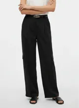 Pantalón negro de tiro medio, corte ancho (wide leg), con pliegues frontales y bolsillos cargo a la altura de los muslos. Se complementa con un cinturón fino negro con hebilla dorada.