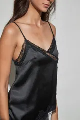 Musculosa de satén color negro, con escote en V y detalles de encaje en el borde del escote y en el ruedo.