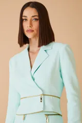 Blazer color amarillo con doble cierre dorado en la parte inferior.