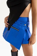 Minifalda azul eléctrico asimétrica con cierre de botones y bolsillo con cremallera.