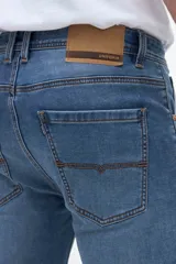 Jean slim fit de color celeste con lavado medio y efecto desgastado sutil. Presenta diseño clásico de cinco bolsillos y cierre frontal con botón y cremallera.