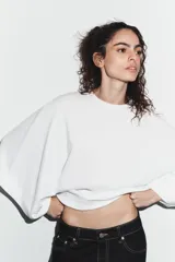 Camiseta de algodón con corte holgado, cuello redondo y mangas anchas tipo capa.