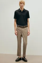 Remera polo negra de manga corta con cuello clásico, tapeta de botones y corte ajustado.