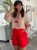 Short color terracota con pinzas frontales, tiro alto y bolsillos laterales.