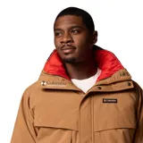Campera técnica Columbia de estilo retro, color camel con forro interior en color rojo. Presenta cierre frontal con solapa, bolsillos frontales amplios, puños ajustables con velcro y cuello alto. Es una prenda versátil con sistema de intercambio que permite usar el forro por separado.