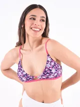 Top de bikini estilo triángulo, estampado floral en tonos azul marino, blanco y fucsia. Presenta un corte central con abertura y ribete fucsia, con tirantes finos ajustables de color fucsia.