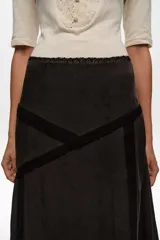 Falda midi color marrón oscuro de corte en línea A, con detalles de encaje negro en la cintura, costuras y dobladillo.