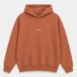 Canguro con capucha de calce oversize, confeccionado en tejido pesado color gris claro. Presenta un bordado minimalista con la palabra 'ASCEND' en la parte superior trasera, puños y ruedo acanalados.
