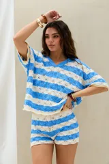 Remera tejida a rayas horizontales en celeste y blanco, con mangas cortas y cuello tipo polo.