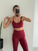 Top deportivo de bretel fino en color bordó, confeccionado en tejido acanalado con diseño de espalda cruzada.