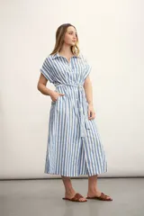 Vestido camisero midi a rayas verticales celestes y blancas, con cuello camisero, mangas cortas con dobladillo, cierre frontal con botones y cinturón de lazo. Incluye bolsillos laterales.